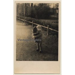 Little Baby Girl Embraces Teddy Bear Outdoors (Vintage RPPC 1930s/1940s)